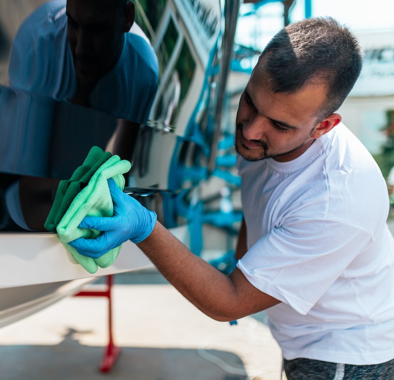 Boat maintenance - A man cleaning boat with cloth. Boat maintenance - A man cleaning boat with cloth.